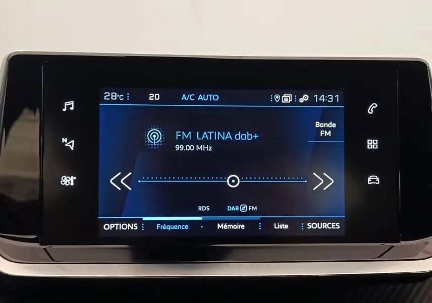 Écran tactile central du tableau de bord du Peugeot 2008 blanc, affichant la radio FM Latina à 99 MHz.