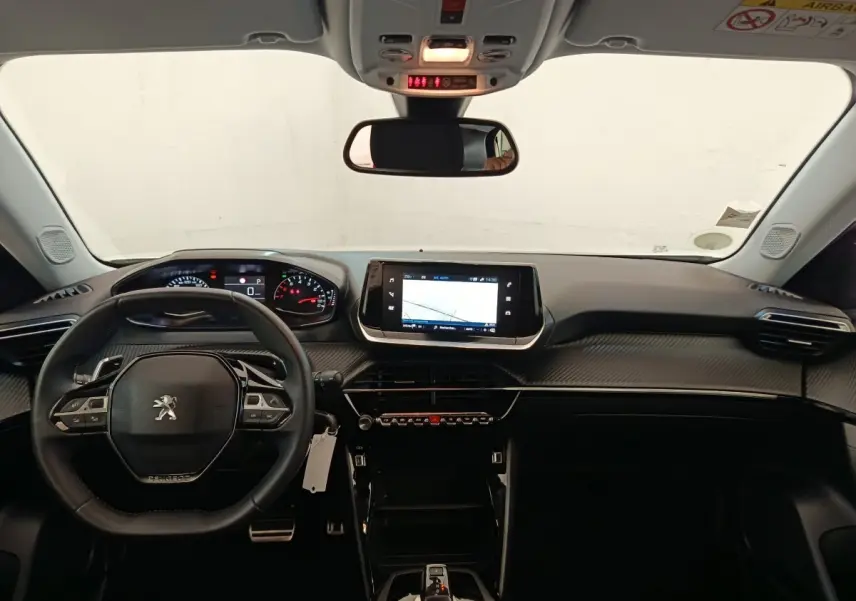 Vue intérieure avant du tableau de bord noir du Peugeot 2008 2021 avec volant cuir multifonctions et écran tactile central.