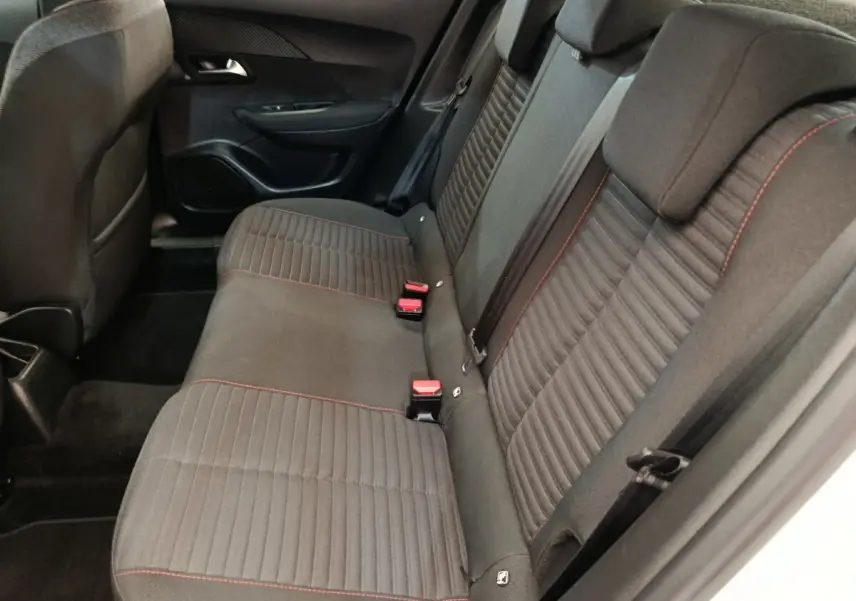 Vue intérieure côté droit sur la banquette arrière grise avec surpiqûres rouges du Peugeot 2008 blanc.