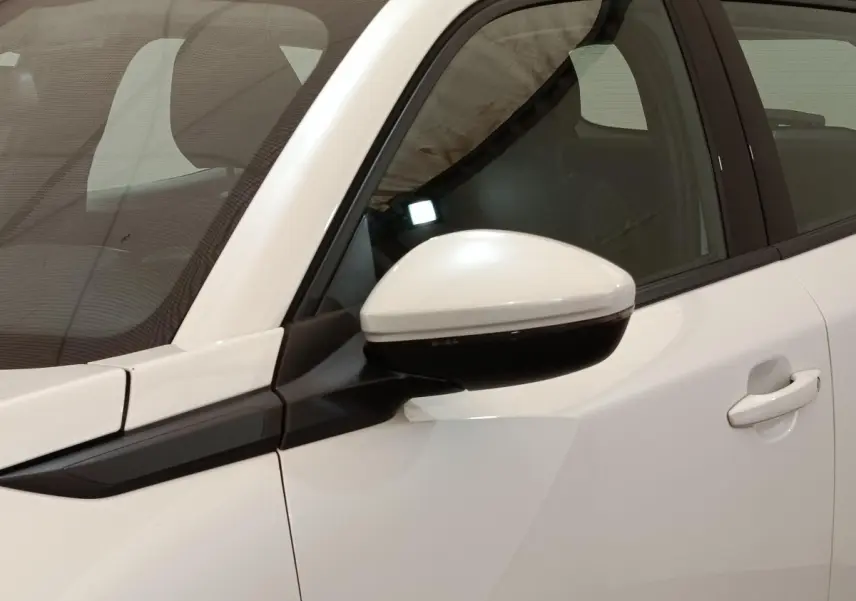 Vue rapprochée du rétroviseur côté conducteur blanc et noir du Peugeot 2008 blanc, avec porte et vitre arrière visibles.