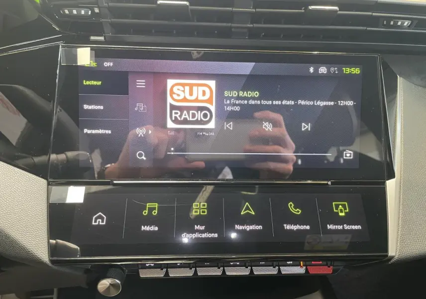 Écran tactile central du Peugeot 308 gris Artense, affichant la radio Sud Radio en intérieur noir et gris.