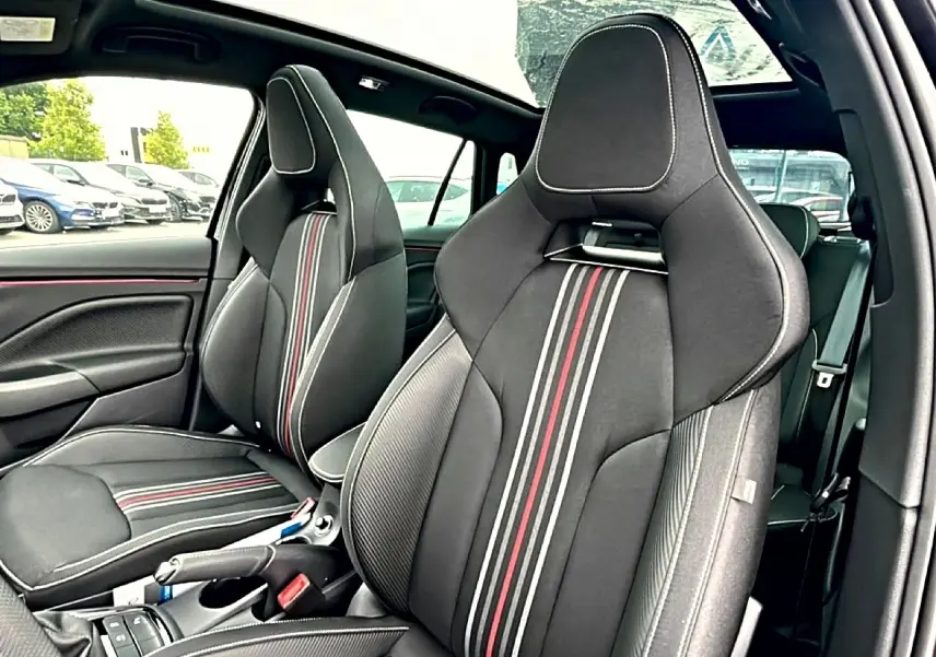 Vue intérieure sur les sièges avant sport noirs avec surpiqûres blanches et bandes rouges du Skoda Kamiq Monte Carlo 2026.