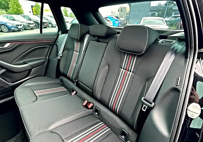 Vue intérieure côté gauche de la banquette arrière noire avec surpiqûres rouges et blanches du Skoda Kamiq Monte Carlo 2026.