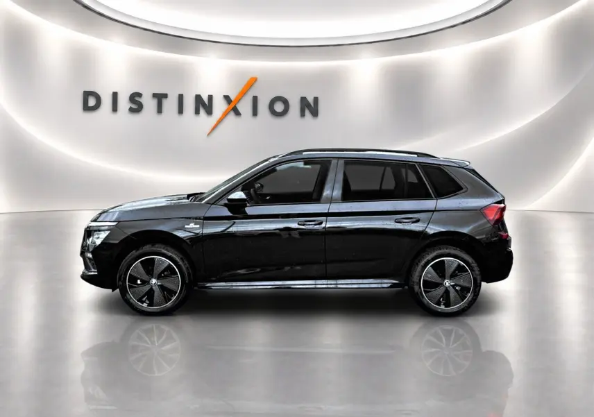 Vue de profil côté gauche d’un Skoda Kamiq noir 2026 finition Monte Carlo dans un showroom lumineux.