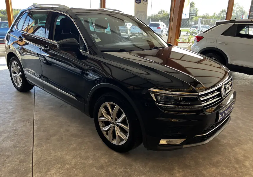 Volkswagen Tiguan noir 2017 en 3/4 avant droit, avec jantes alliage et calandre chromée visible en showroom.
