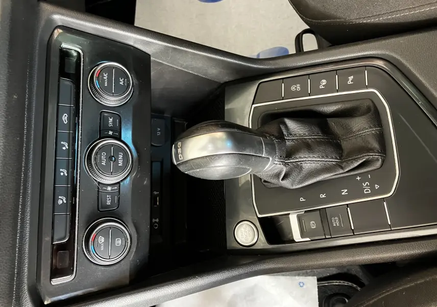 Gros plan sur la console centrale noire du Volkswagen Tiguan 2017, mettant en valeur le levier de vitesses DSG et les commandes de climatisation.