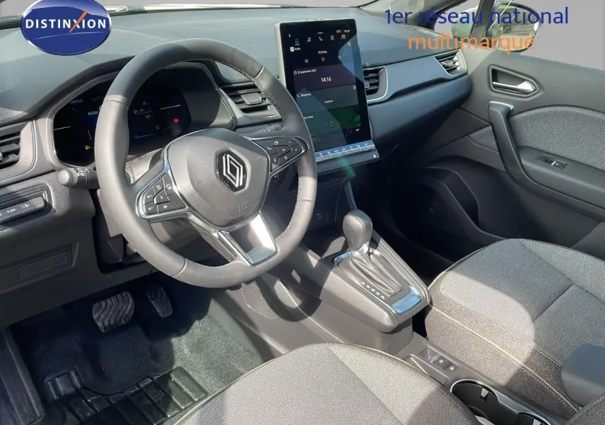 Intérieur du Renault Captur 2025 en tissu gris, vue côté conducteur sur volant, écran tactile et levier de boîte auto.