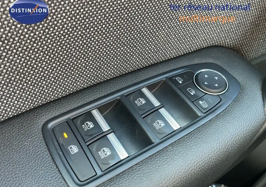 Gros plan sur les commandes des vitres électriques et rétroviseurs du côté conducteur d'un Renault Captur noir étoile métal toit gris.