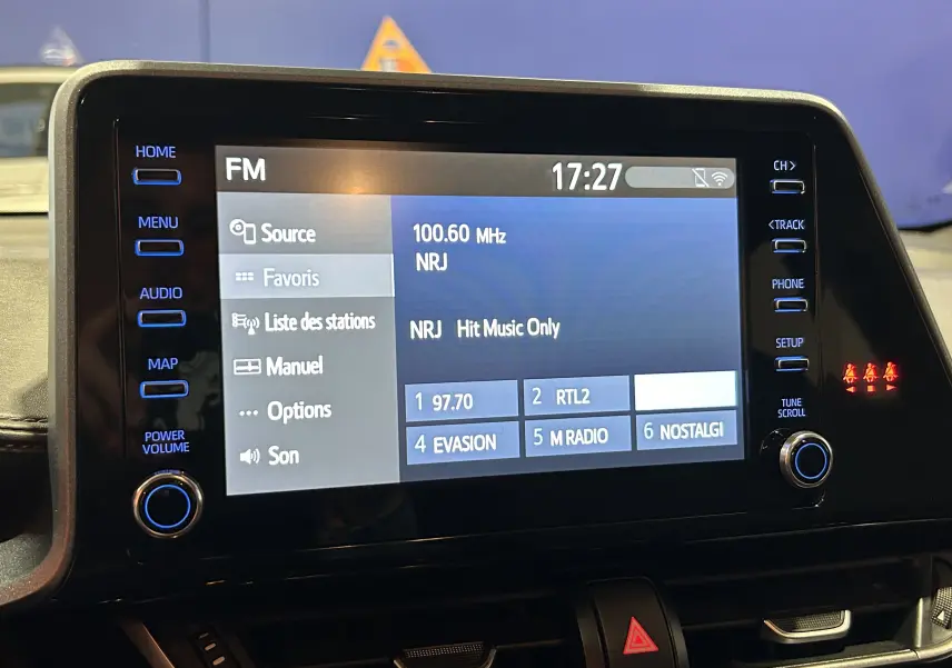 Écran tactile central du Toyota C-HR Hybride 2021 affichant les stations FM avec commandes autour en intérieur noir.
