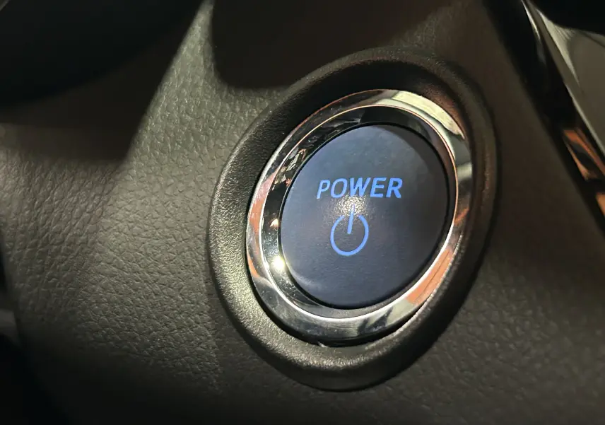 Bouton de démarrage Power en gros plan sur le tableau de bord noir du Toyota C-HR Hybride 122h Edition 2WD.