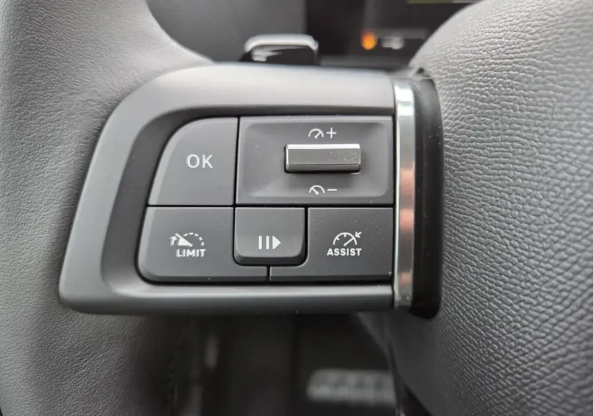 Gros plan sur les commandes au volant à gauche du Citroën C4 III blanc Okenite avec toit noir, boutons de régulateur et assistances.
