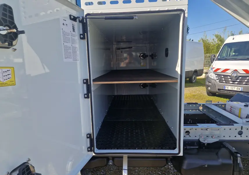 Vue de face du coffre blanc ouvert du châssis cabine Iveco Daily 35C16 avec étagère intérieure visible.