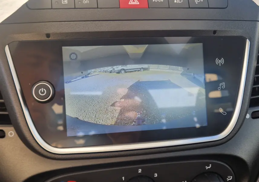 Vue de l'écran de caméra de recul du tableau de bord du Daily Chassis Cabine blanc, affichant l'arrière avec benne et coffre.