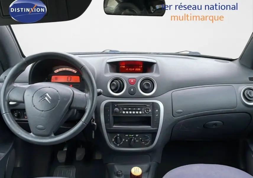 Vue intérieure du tableau de bord de la Citroën C3 Pluriel 2007, volant à gauche et levier de vitesse manuel ivoire.