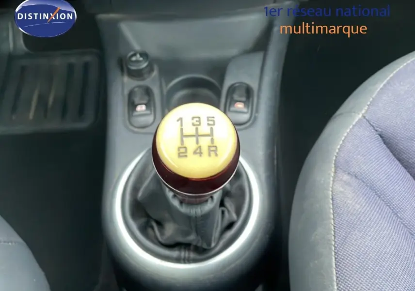 Le levier de vitesses manuel ivoire et marron de la Citroën C3 Pluriel 2007 vu de dessus, avec sièges tissu noir-beige.