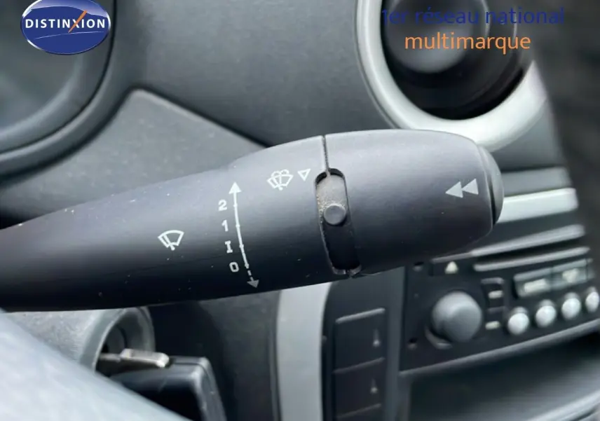 Gros plan sur la commande d’essuie-glace à gauche du volant dans l’habitacle noir et beige d’une Citroën C3 Pluriel ivoire.