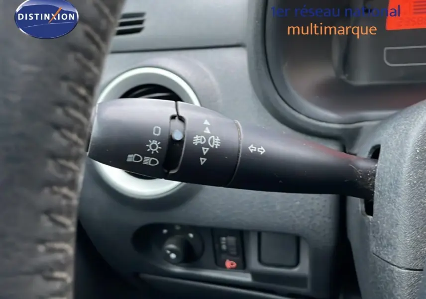 Gros plan sur la commande de clignotant à gauche du volant d’une Citroën C3 Pluriel ivoire de 2007.