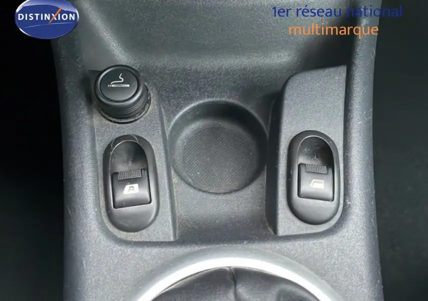 Gros plan sur la console centrale noire de la Citroën C3 Pluriel 2007, montrant les commandes des vitres électriques.