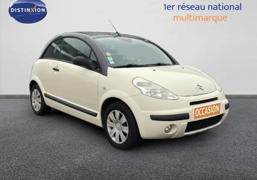 Citroën C3 Pluriel ivoire vue 3/4 avant droit avec toit noir et plaque "OCCASION" orange.