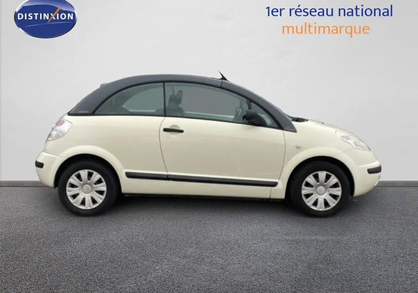 Profil droit d'une Citroën C3 Pluriel ivoire de 2007 avec toit noir et jantes acier, sur fond neutre.