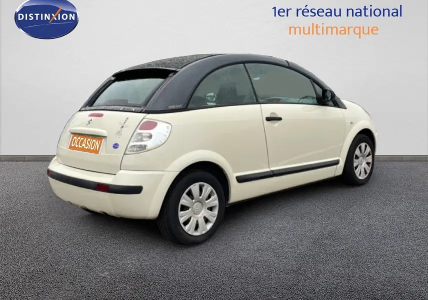 Citroën C3 Pluriel ivoire vue 3/4 arrière côté droit avec toit noir et jantes acier.