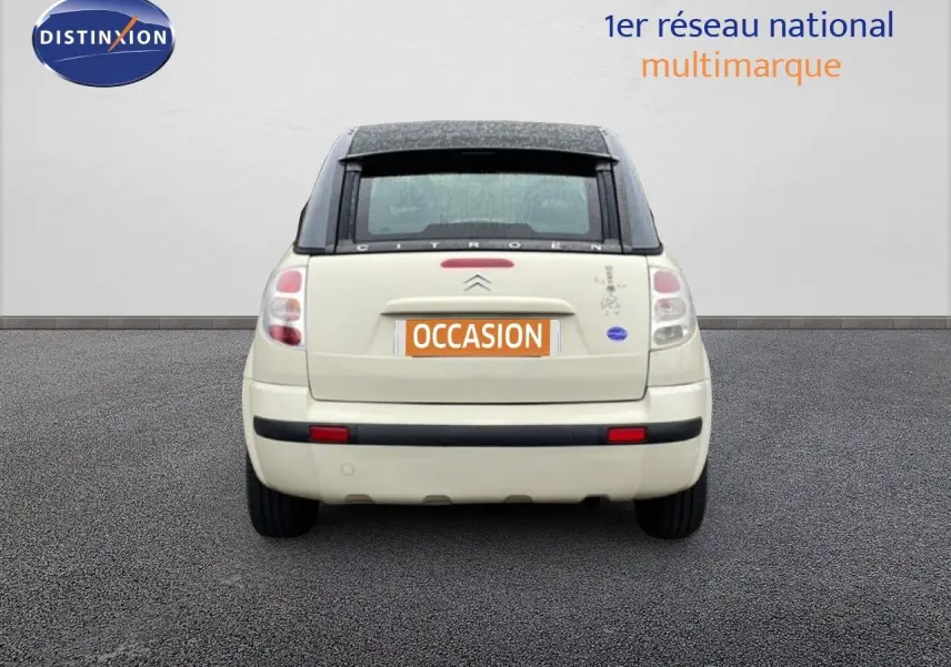 Vue arrière d'une Citroën C3 Pluriel ivoire de 2007 avec toit noir et plaque d'immatriculation orange "OCCASION".
