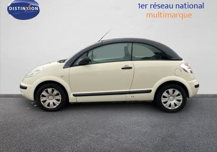 Profil droit d'une Citroën C3 Pluriel ivoire 2007 avec toit noir, roues acier et poignées noires.