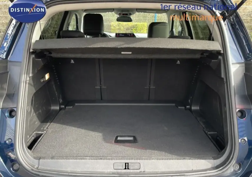 Coffre ouvert vu de l'arrière d'un Citroën C5 Aircross bleu 2024, montrant l'espace de chargement et la plage arrière.