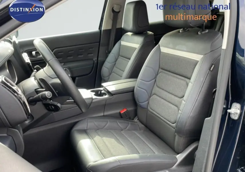 Vue intérieure côté conducteur du Citroën C5 Aircross bleu 2024, sièges en cuir et tissu gris avec volant multifonctions.