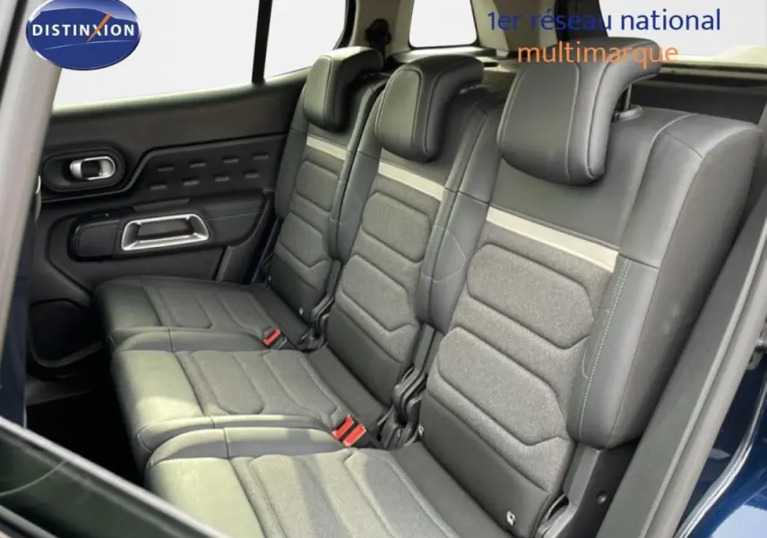 Vue intérieure côté gauche montrant les sièges arrière en tissu et cuir gris du Citroën C5 Aircross bleu 2024.