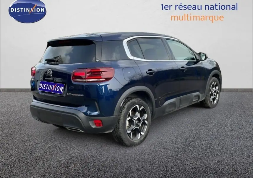 Vue 3/4 arrière droite d'un Citroën C5 Aircross bleu 2024 avec jantes aluminium et vitres teintées.