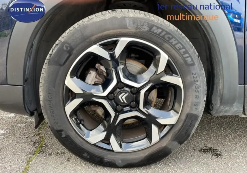 Gros plan sur la jante aluminium noire et argentée du côté avant gauche d’un Citroën C5 Aircross bleu 2024.