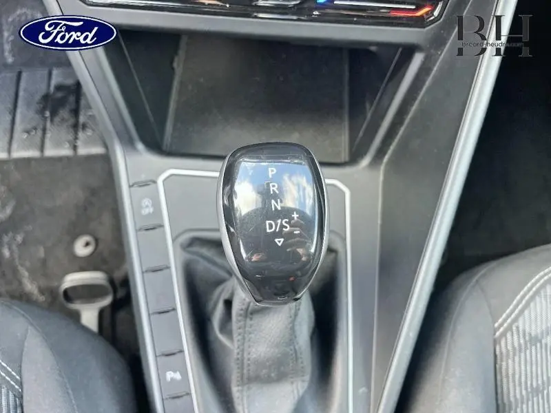 Gros plan sur le levier de vitesses automatique noir dans l'habitacle d'une Volkswagen Polo, vue de dessus.