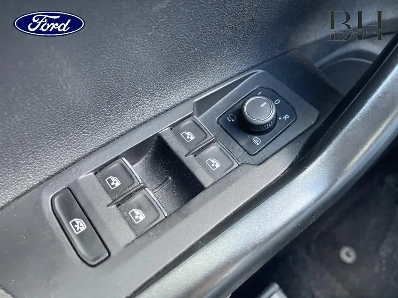 Détail des commandes de lève-vitres et réglage des rétroviseurs côté conducteur d'une Volkswagen Polo 1.0 TSI argent métallisé.