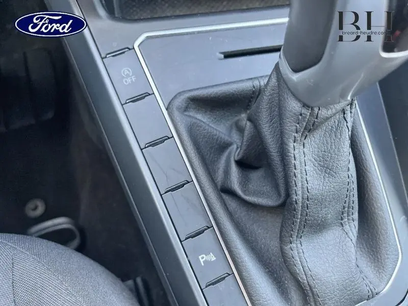 Gros plan sur la console centrale avec levier de vitesse cuir noir et boutons de commande, intérieur Volkswagen Polo.