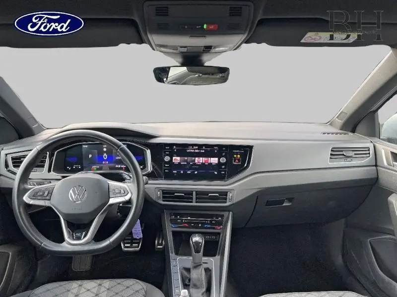 Vue intérieure avant du tableau de bord et volant cuir multifonction d'une Volkswagen Polo 1.0 TSI R-Line gris métallisé.