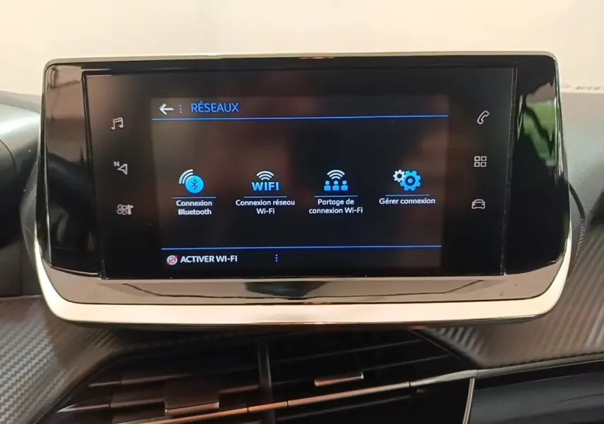 Écran tactile central de la Peugeot 208 PureTech 100 S&S Active Pack 2023 affichant les options de connexion Wi-Fi et Bluetooth.