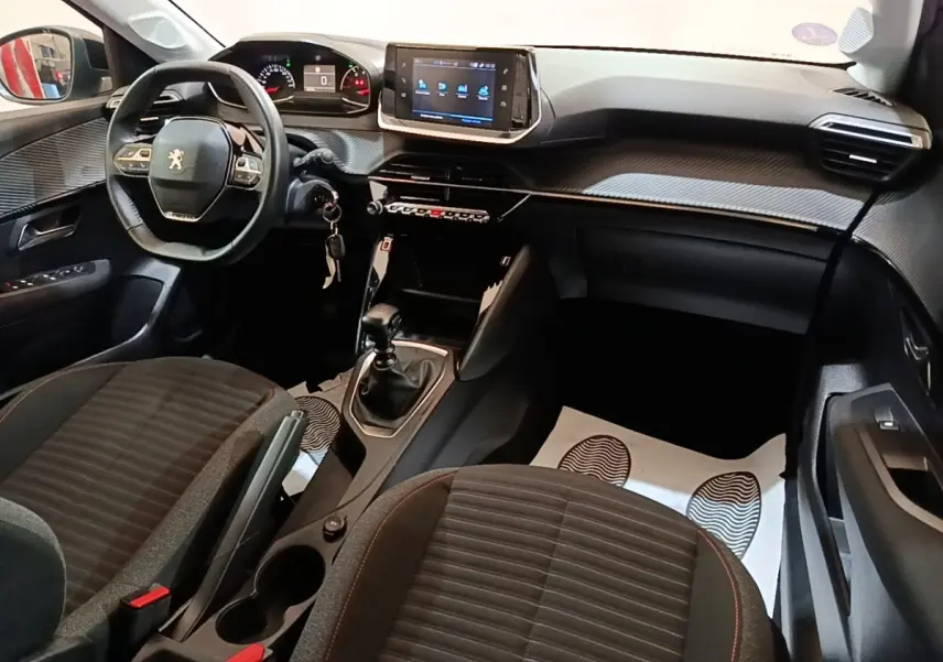 Intérieur de la Peugeot 208 gris clair, vue côté conducteur, volant cuir multifonctions et écran tactile central.