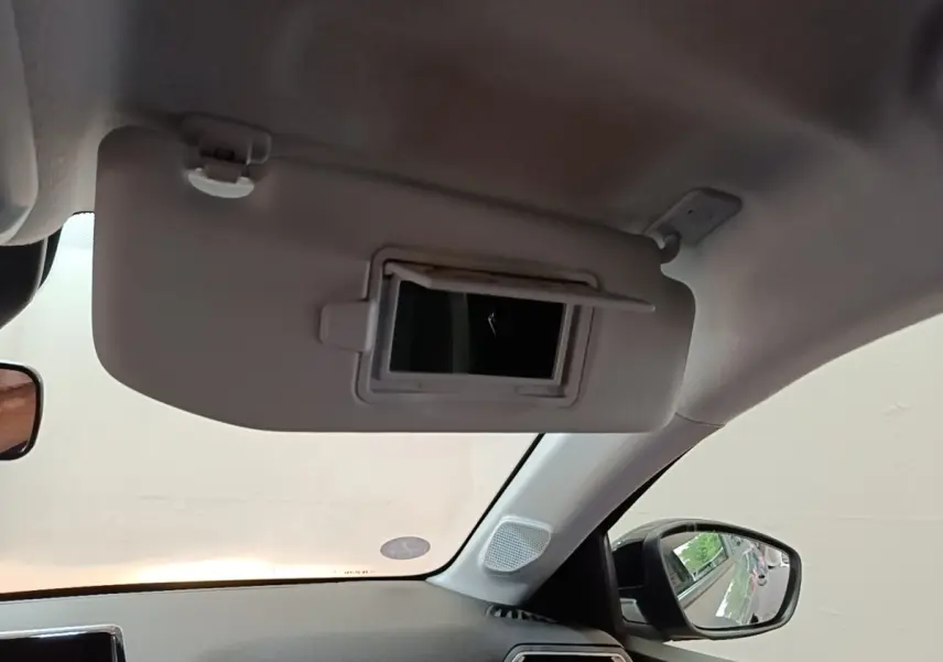 Détail du pare-soleil côté conducteur avec miroir intégré dans l'habitacle d'une Peugeot 208 gris clair.