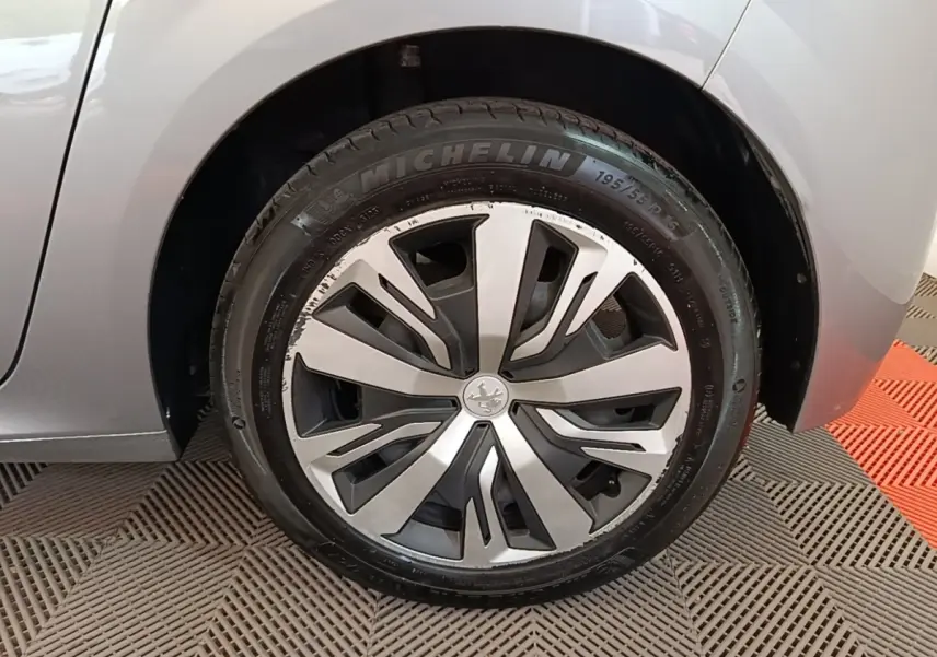 Gros plan sur la roue avant droite gris clair de la Peugeot 208 2023 avec jante alliage et pneu Michelin.