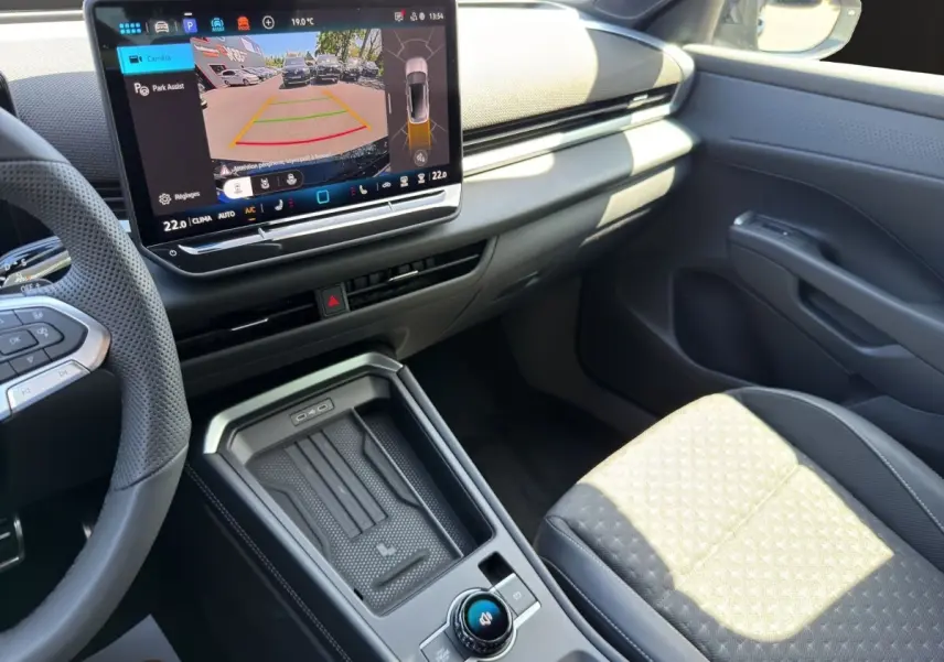 Vue intérieure côté passager du Volkswagen T-Roc noir 2026, avec écran tactile affichant l'aide au stationnement.