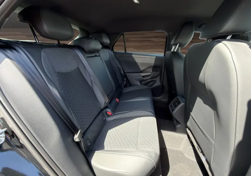 Vue latérale intérieure côté gauche des sièges arrière noirs en cuir et tissu du Volkswagen T-Roc 1.5 eTSI EVO2 2026.