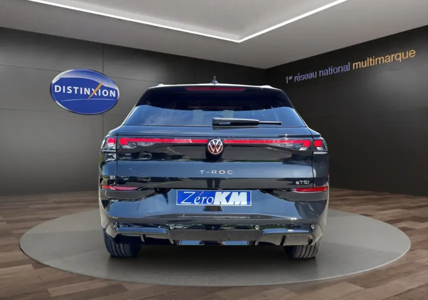 Vue arrière du Volkswagen T-Roc noir 2026 avec feux LED traversants et badge eTSI visible sur fond showroom.