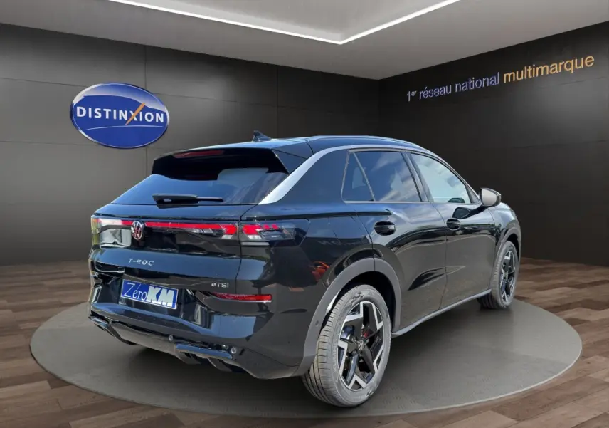 Volkswagen T-Roc noir vue 3/4 arrière droit, avec feux arrière LED et jantes alliage distinctives.