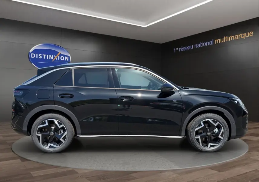Vue latérale droite du Volkswagen T-Roc noir 2026 avec jantes alliage et toit ouvrant panoramique en showroom.