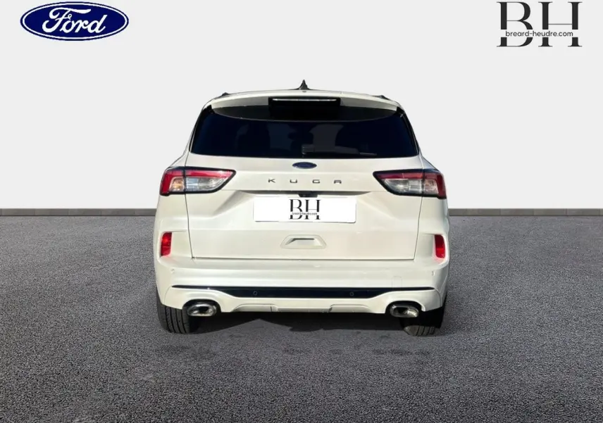 Vue arrière du Ford Kuga blanc Premium Platinum de 2021, avec hayon mains libres et double sortie d’échappement visible.