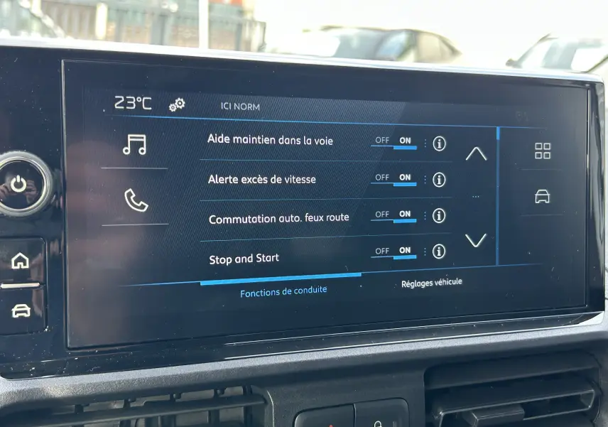 Écran tactile central du Peugeot Partner Fourgon 2025 affichant les réglages d’aide à la conduite et température à 23°C.