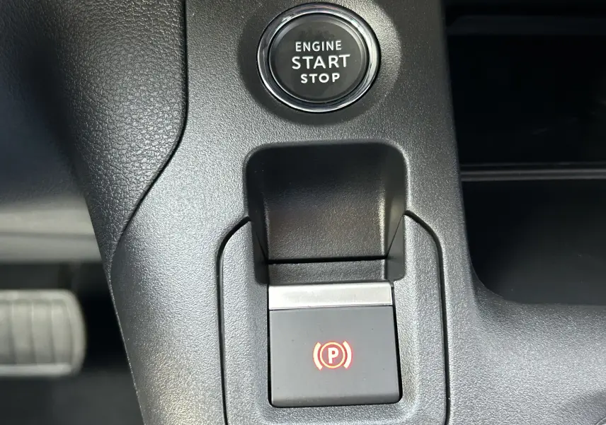 Bouton start/stop moteur et frein à main électrique allumé dans l'habitacle du Peugeot Partner Fourgon blanc 2025.