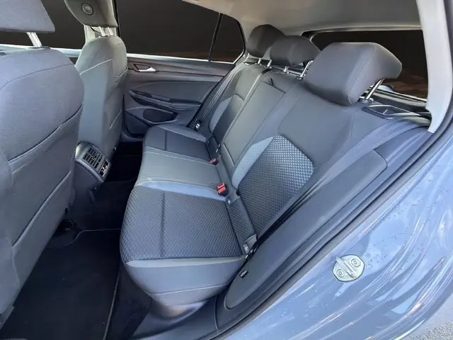 Vue intérieure côté droit montrant la banquette arrière grise avec sièges tissu et vitres arrière surteintées.