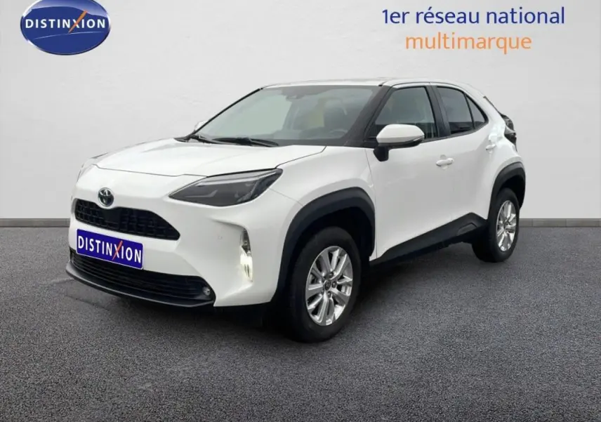Toyota Yaris Cross Hybrid blanc vue 3/4 avant droit avec jantes aluminium et protections noires contrastées.